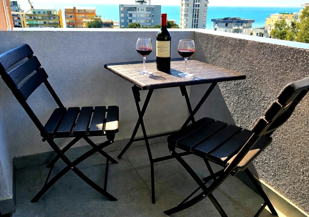 Private balcony with sea view, table set with two wine glasses