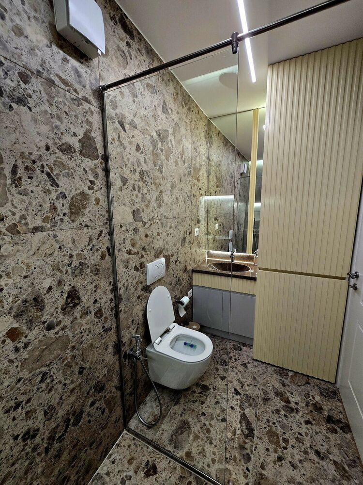 Modern bathroom with glass shower screen and marble-look tile