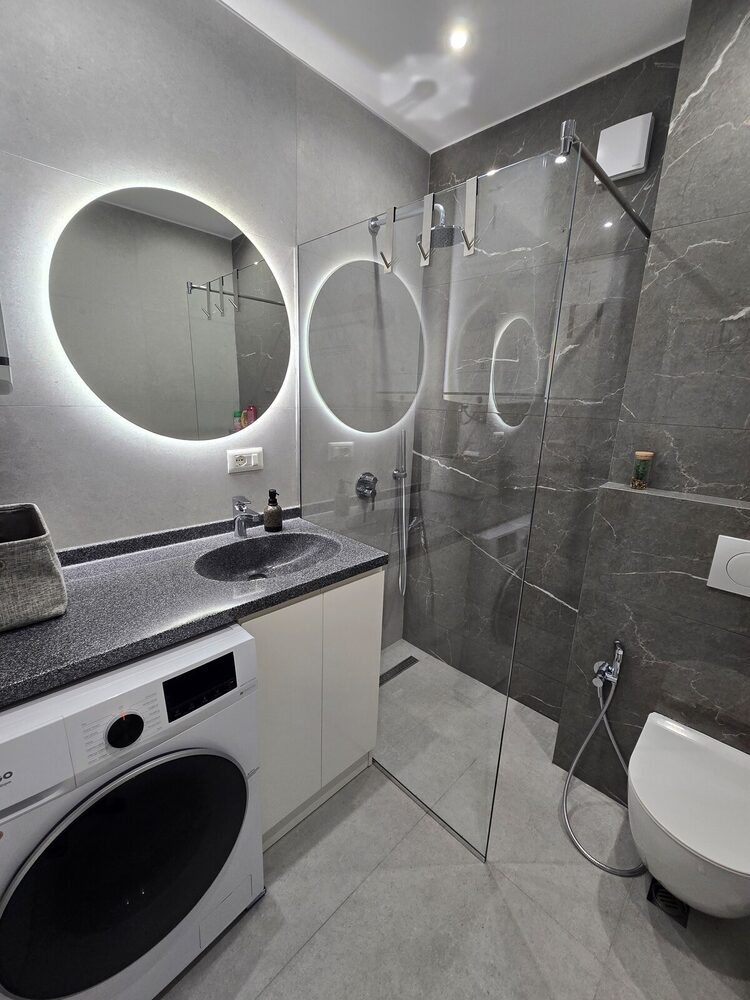 Modern bathroom with round backlit mirrors