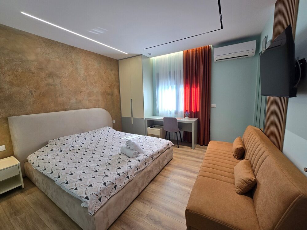Bedroom with king-size bed and desk workspace by the window
