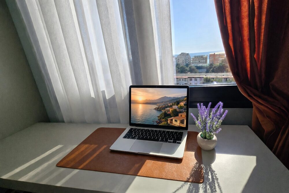 Desk workspace with laptop by the window