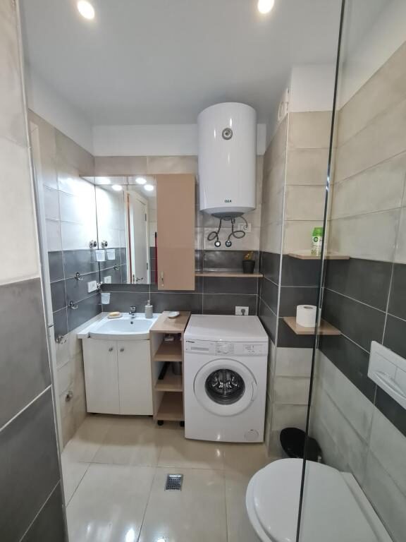 Bathroom with mirror, sink, and washing machine
