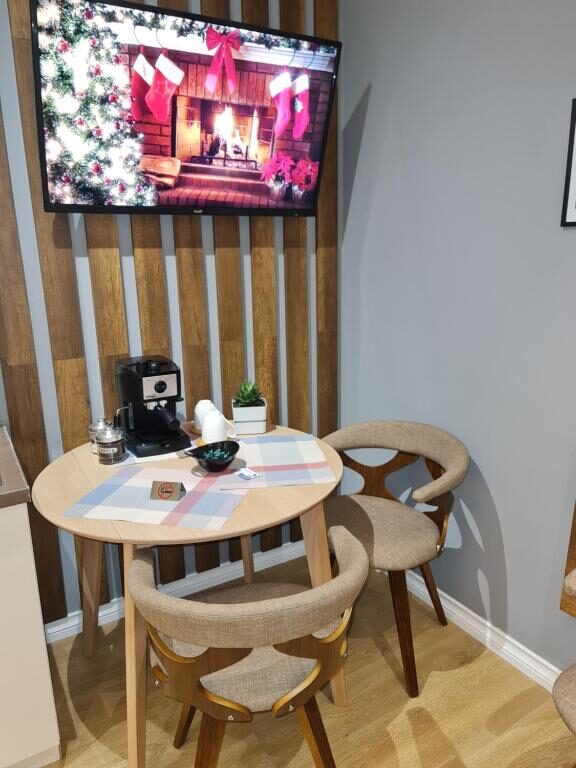 Dining table with wall-mounted TV and kitchen counter