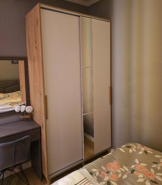Sliding-door wardrobe beside the bed