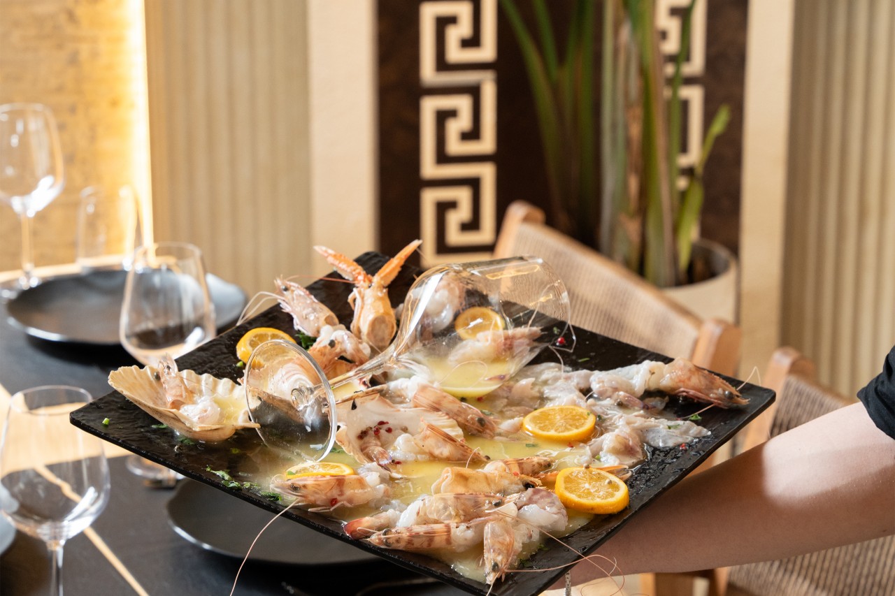A chilled seafood platter of prawns, scallop, and lemon served tableside at a Durrës restaurant